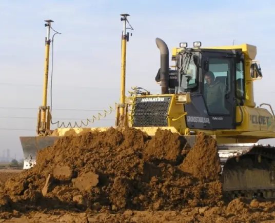 Bulldozer van Cloet met GPS-masten bij grondstabilisatie