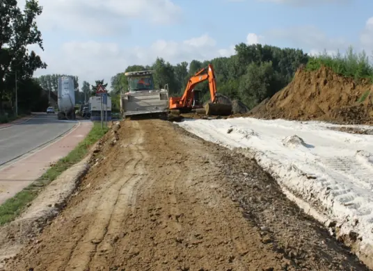 Grondstabilisatie met kalk langs een weg, met frees en graafmachine van Cloet